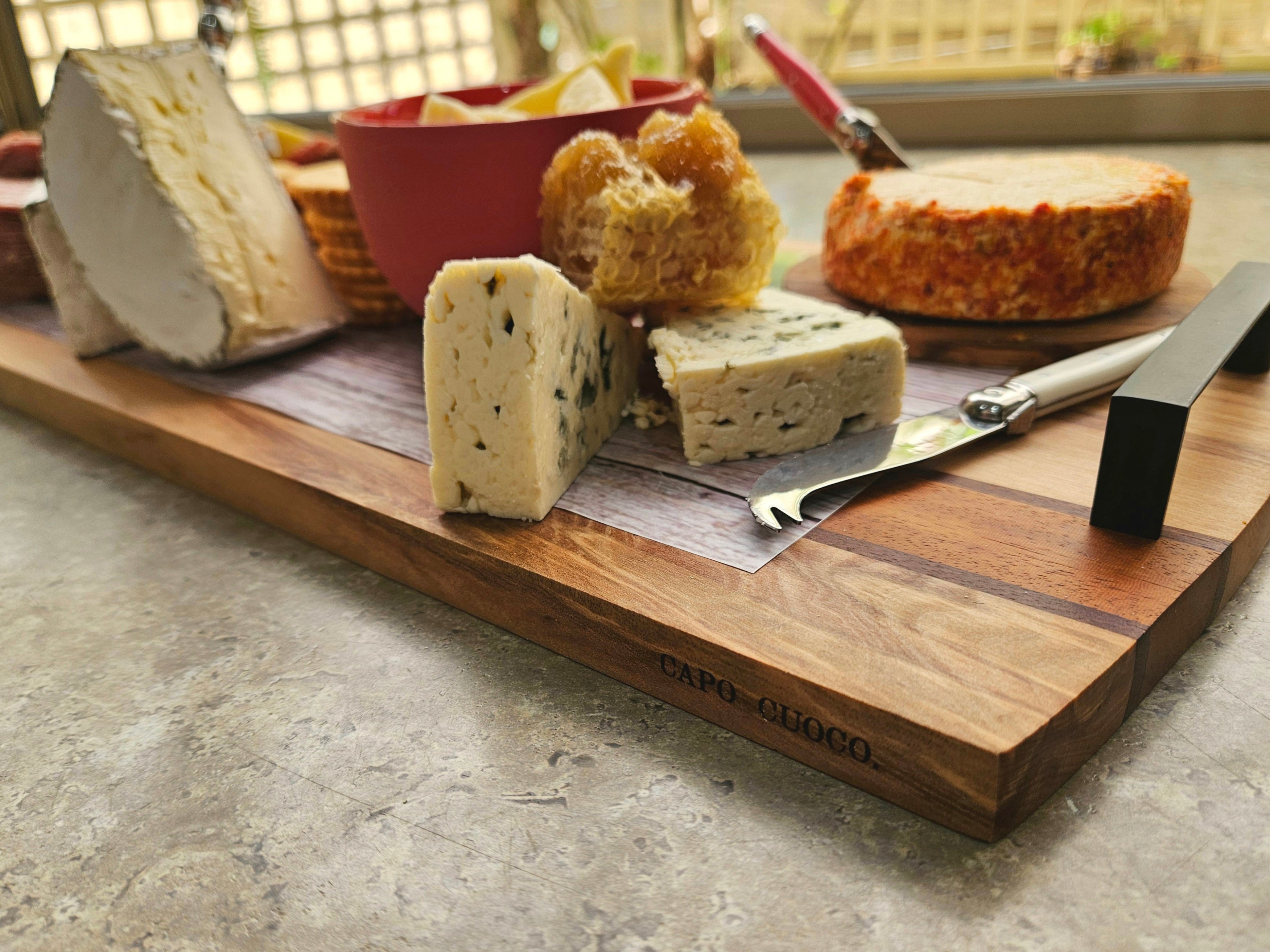 Wooden cheese board with assorted cheeses