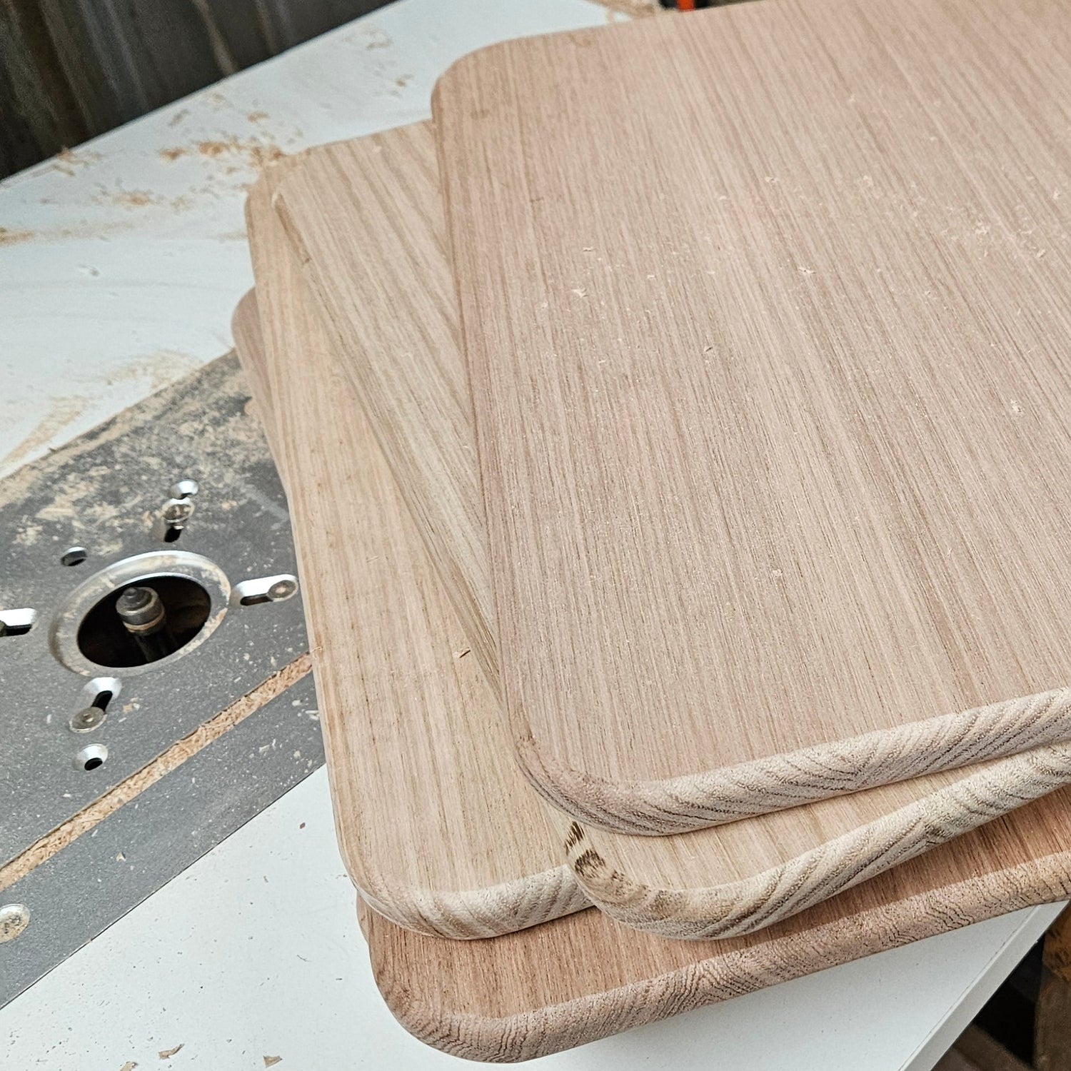 Wooden cutting boards on a table with a workshop background