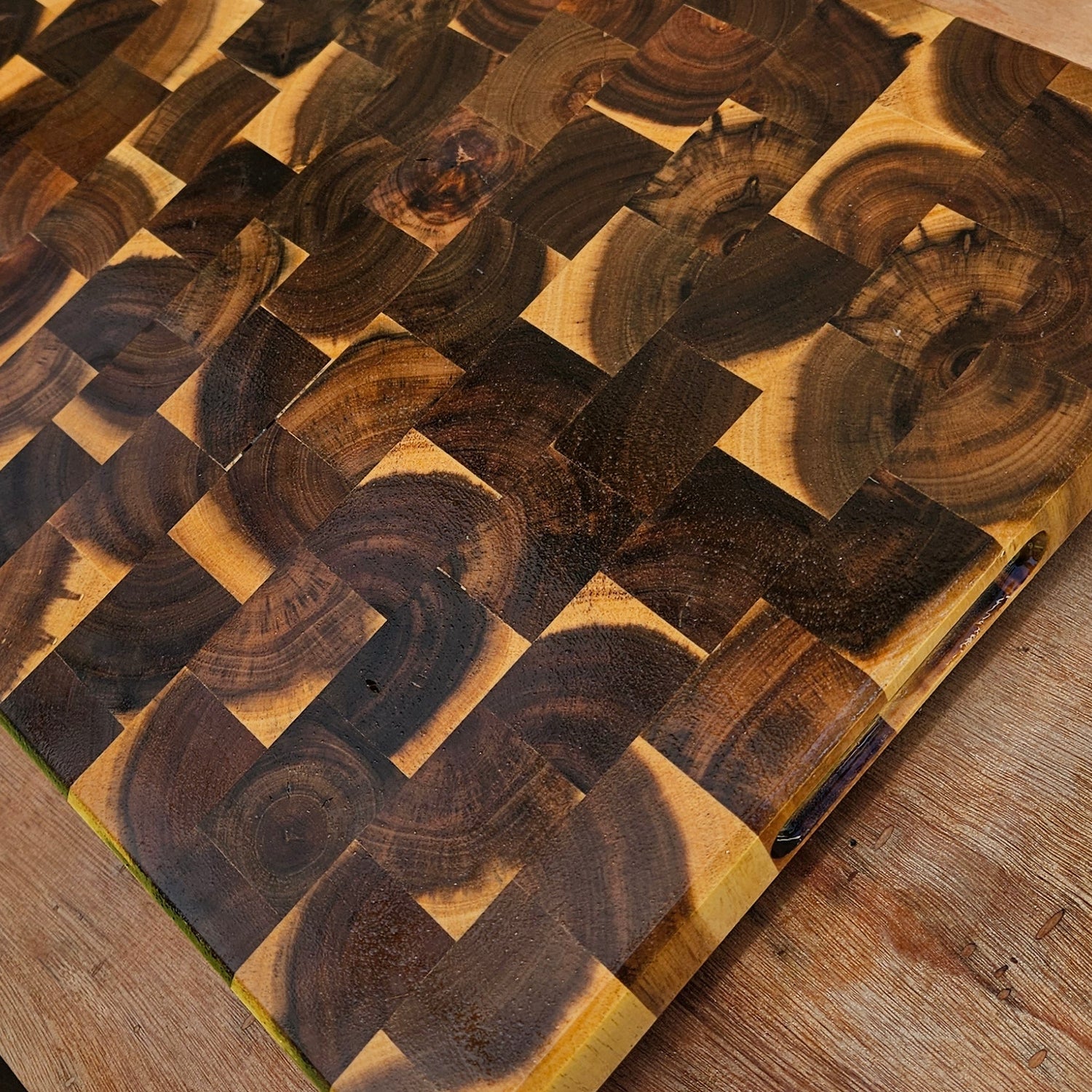 Wooden cutting board with woven pattern on a wooden surface